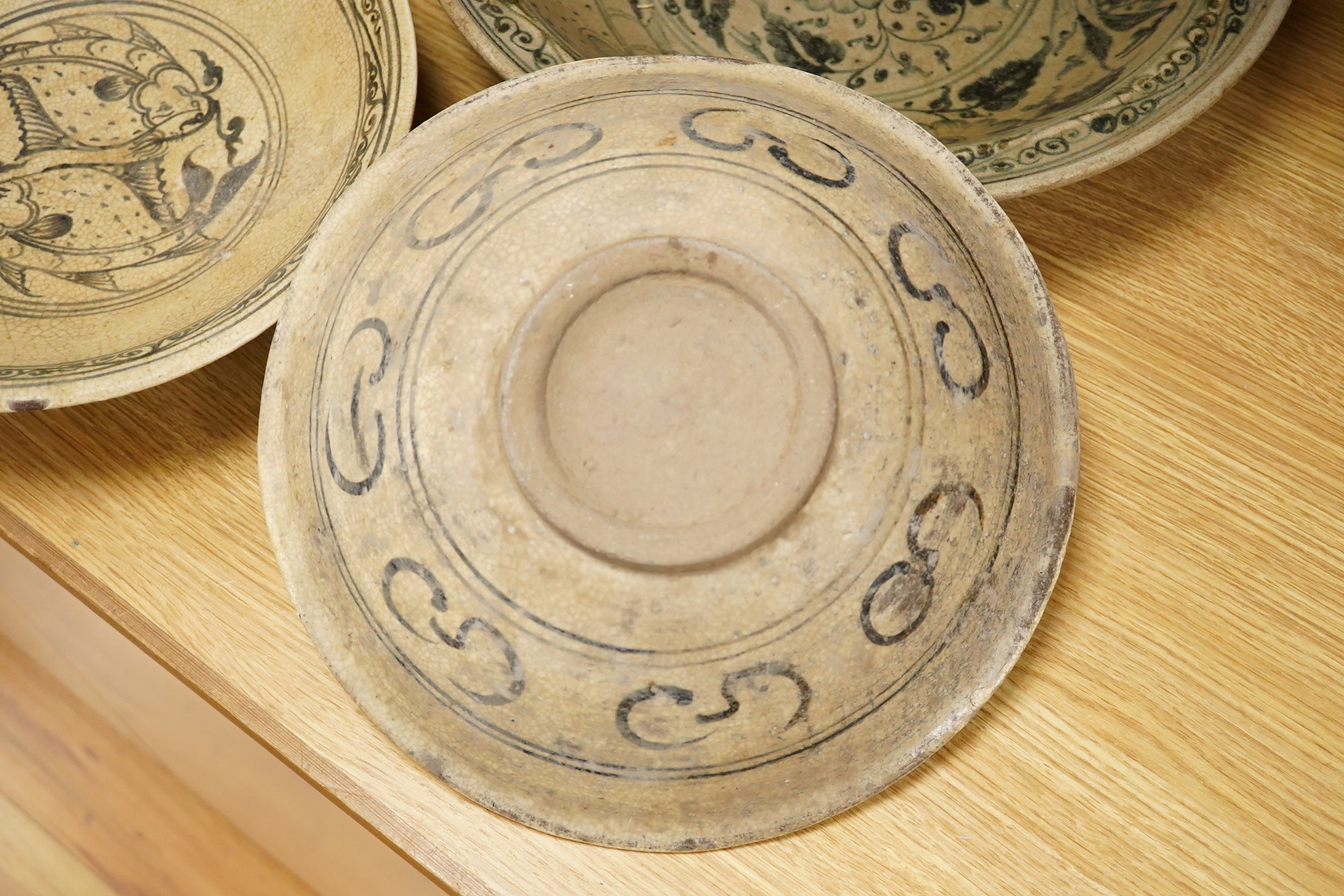 A group of three Thai underglaze blue or black crackle glaze dishes, two decorated with fish, largest 38cm in diameter
